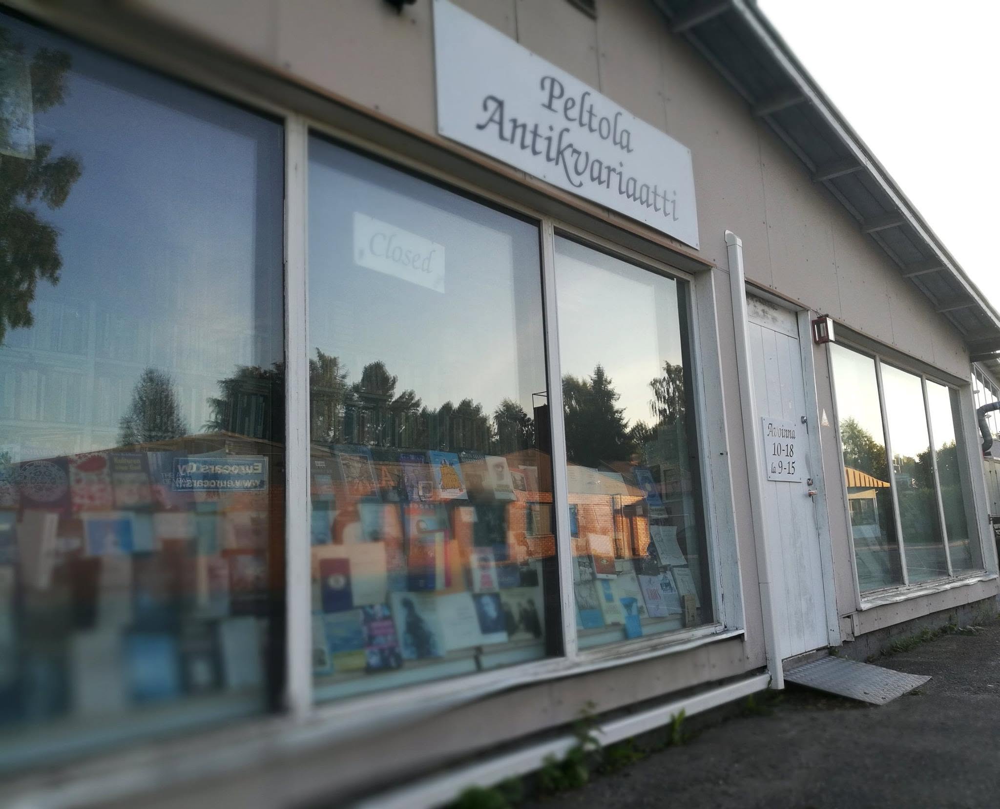 Peltolan Antikvariaatin julkisivu: käsin maalattu kyltti ja näyteikkuna täynnä kirjoja.